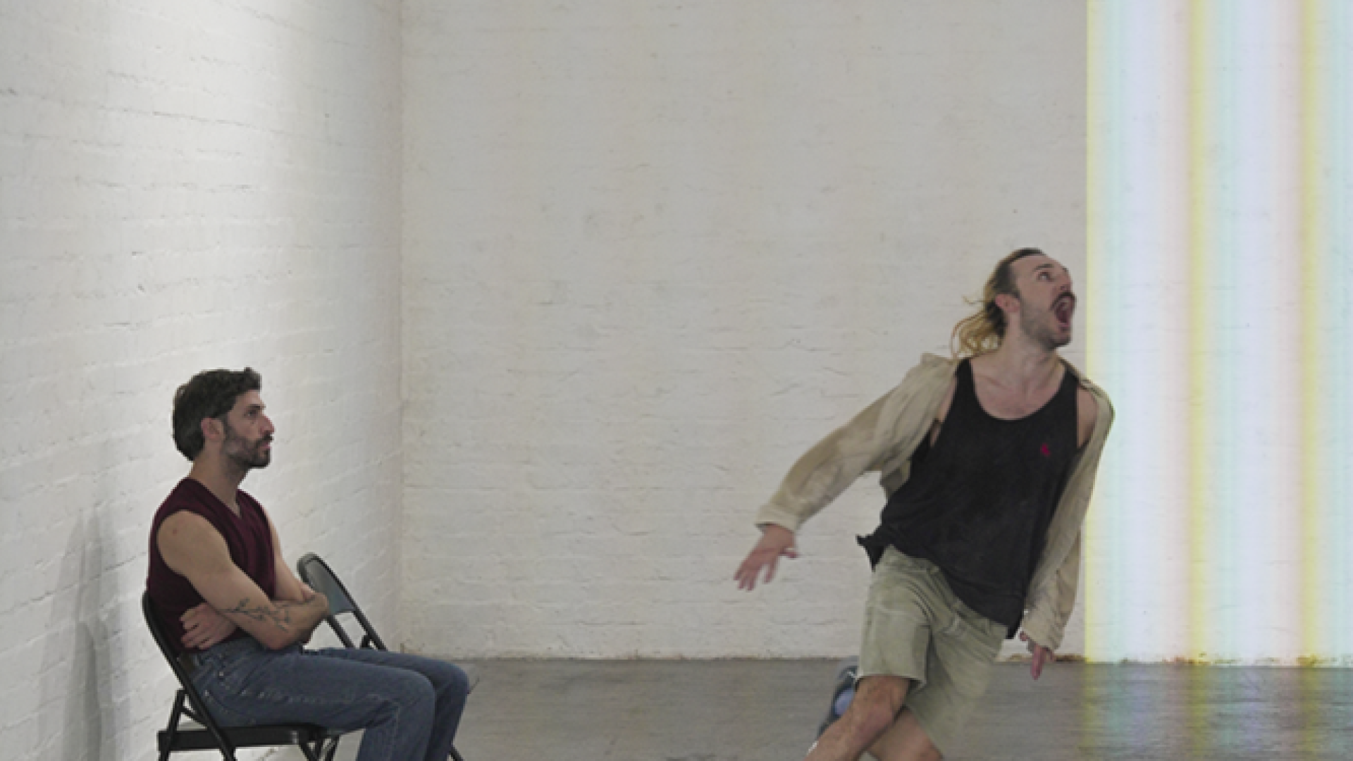 One artist sitting and the other running in a room