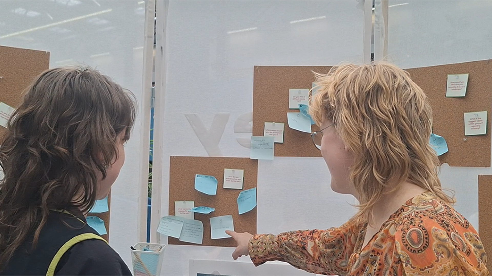 Visitors discussing the community wall.