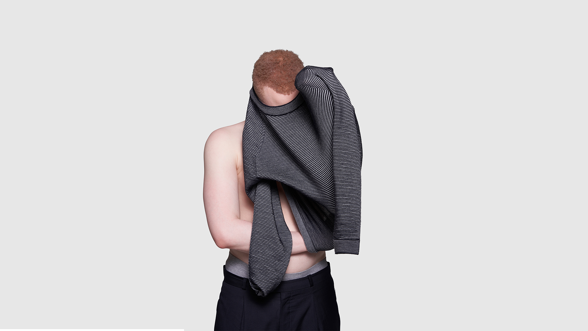 Sanele putting on Shadow Knit jumper