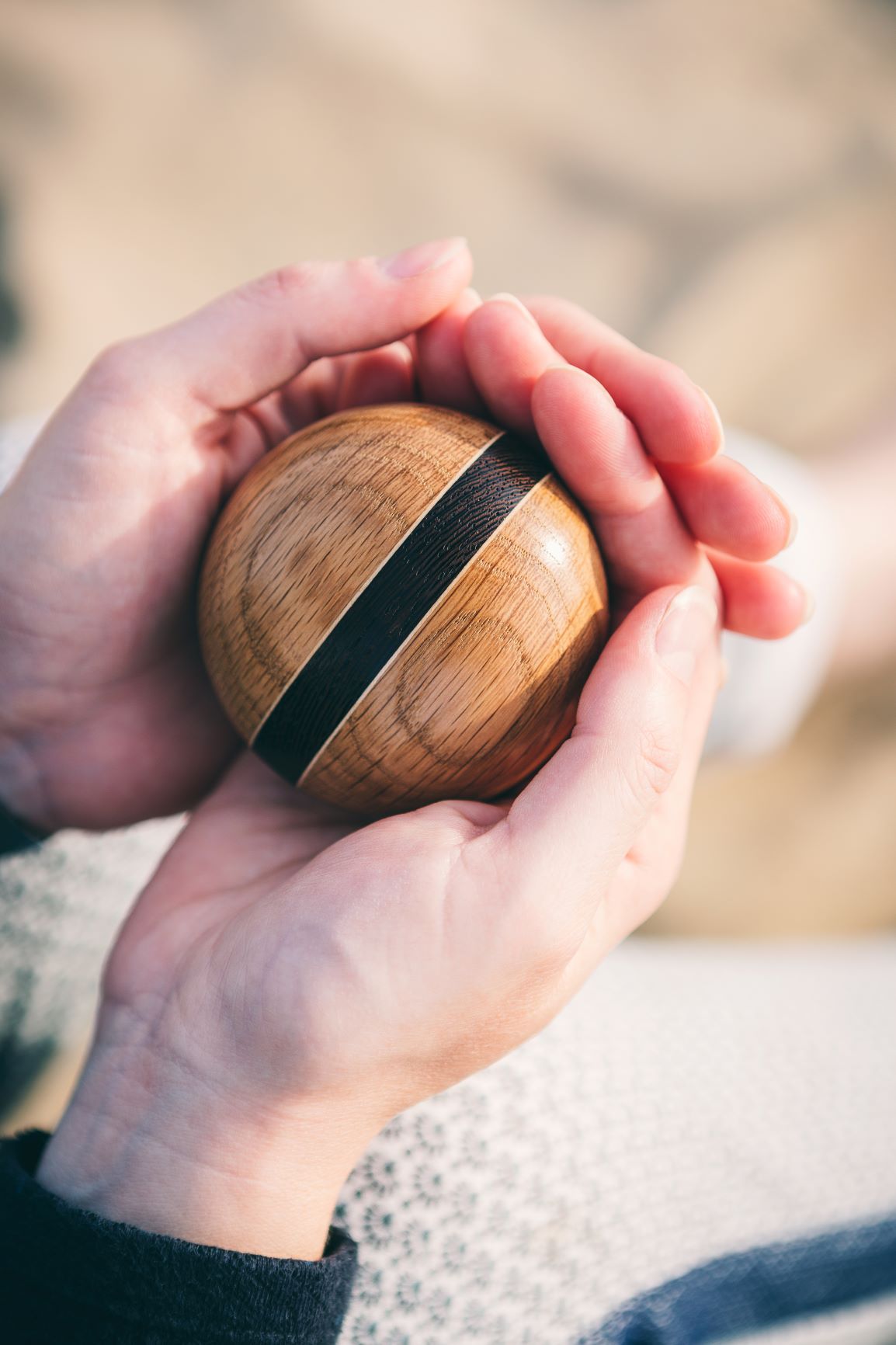 Holding the LittleWood mini urn on the beach