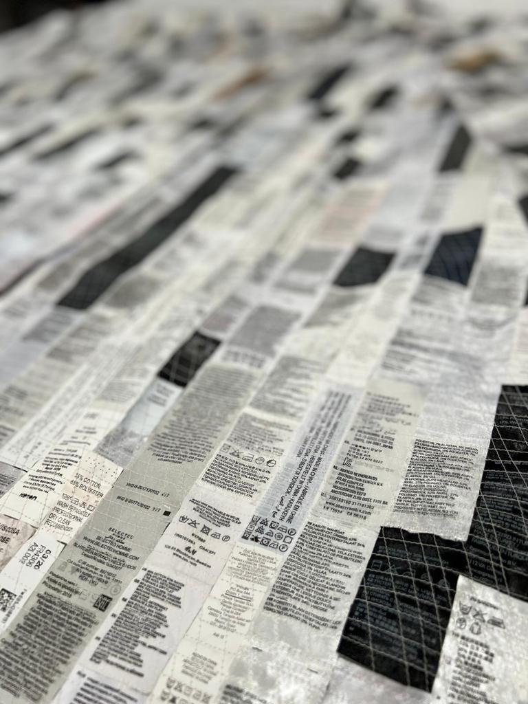 Cloak with 'Made in'-labels by Lena Winterink